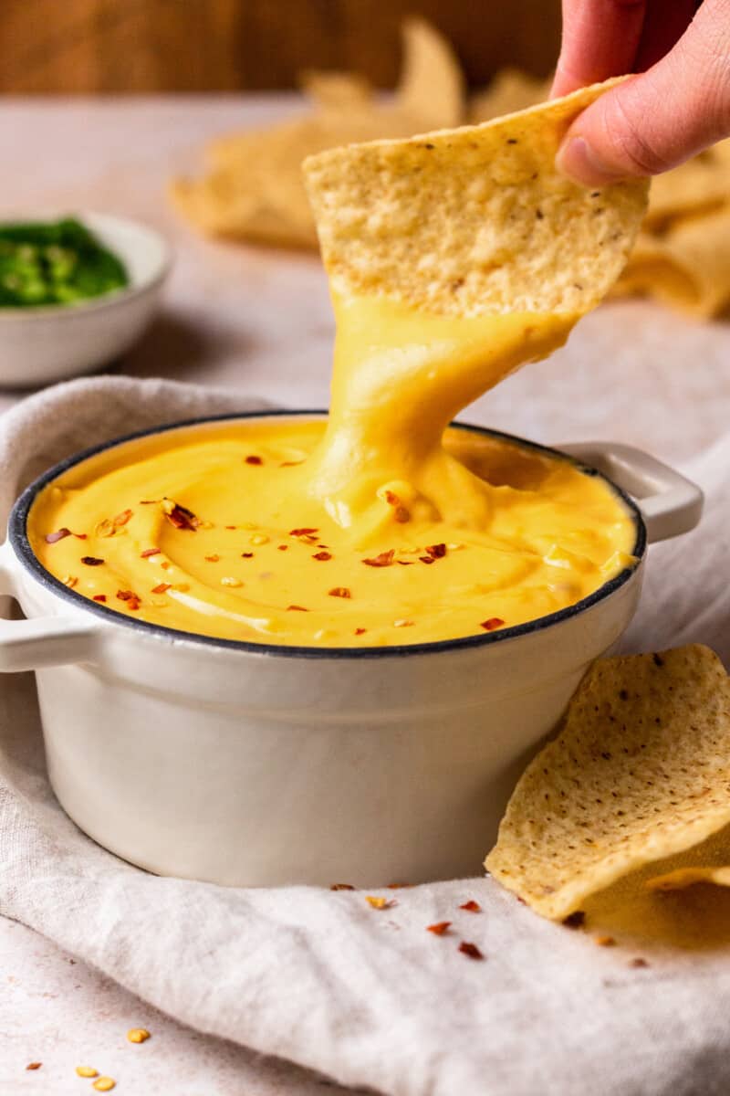 Nacho Cheese Sauce is something everyone should be able to make. An easy cheese dip (made in 5 minutes!) always comes in handy! This homemade nacho cheese sauce recipe is so delicious and so quick. Make it in a flash, dip in some chips, or use this versatile cheese sauce on all kinds of recipes! nacho cheese sauce with tortilla chips